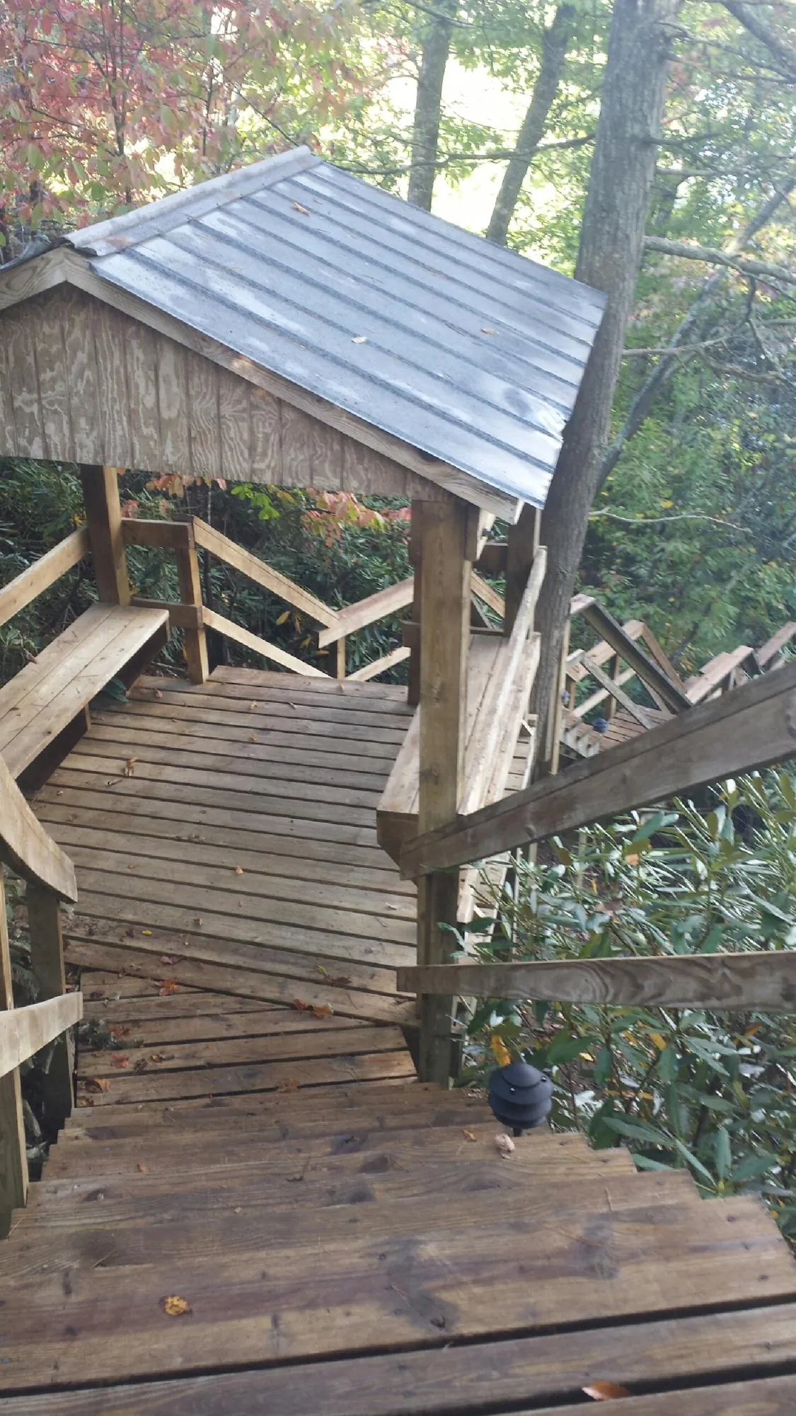 Metal roofed shelter over wooden steps on a wooded walkway — Skylight Repair & Installation work by our crew in Page