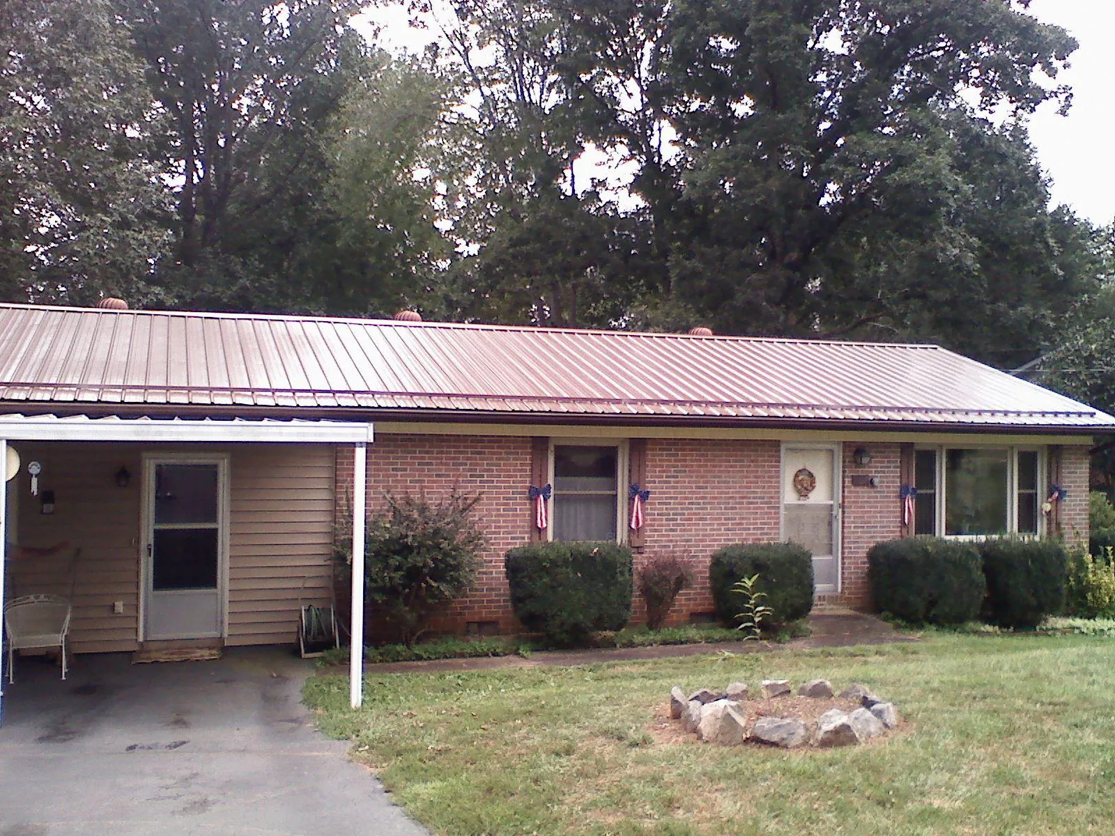 Bronze metal roof and carport on a brick ranch home — Roof Repair work by our crew in Page